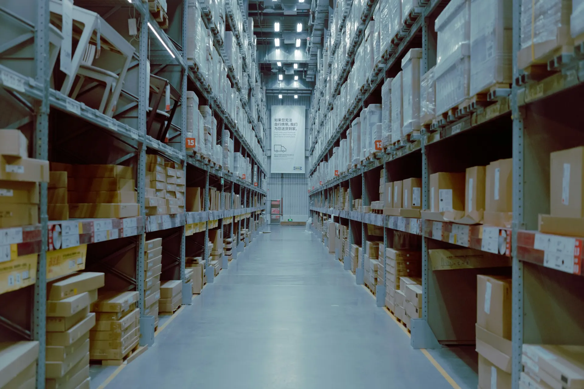 Rows of business computer hardware and IT equipment arranged on supply shelving, representing technology wholesale categories.